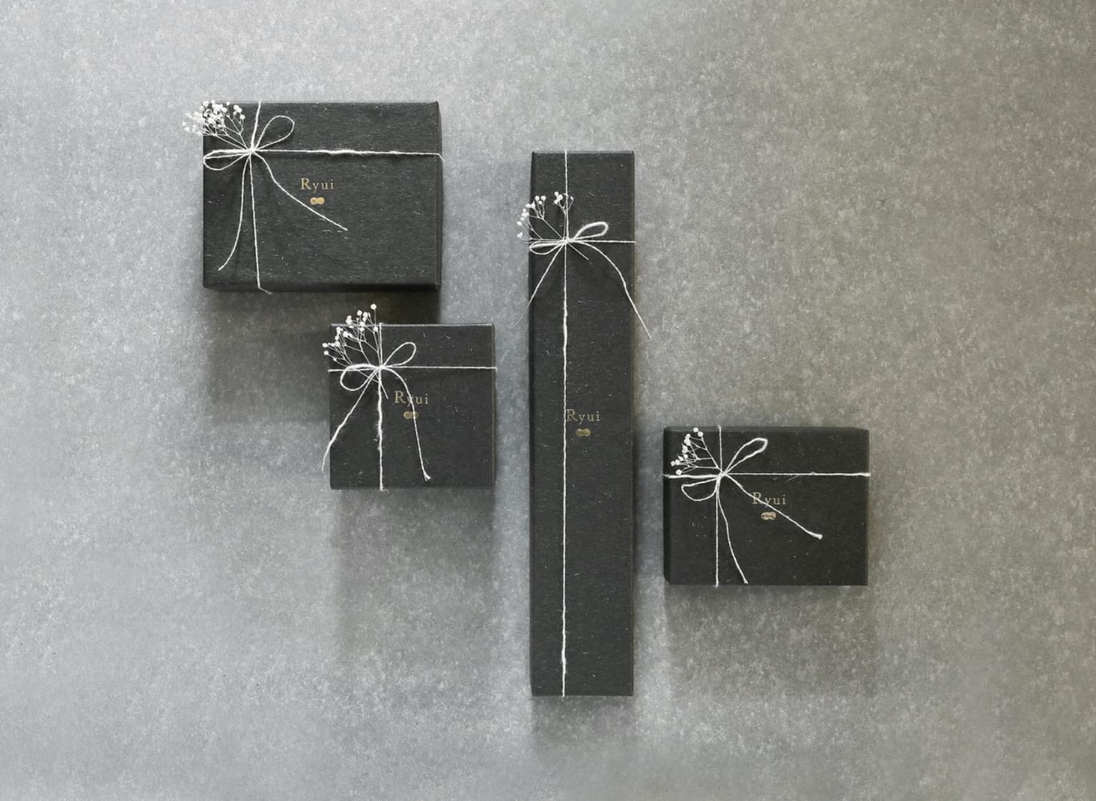 Four size boxes wrapped with white branches and white string